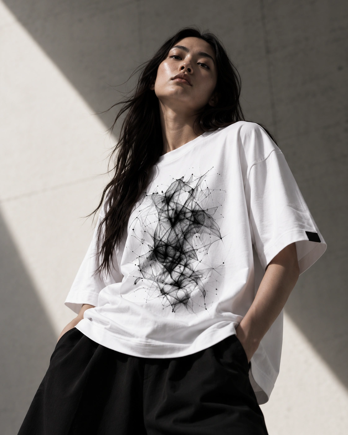 A white oversized T-shirt with abstract black artwork, worn with confidence